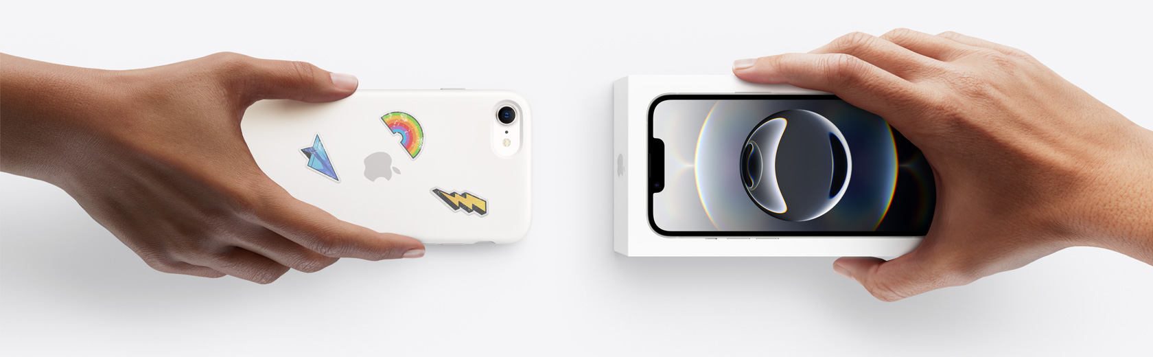 一隻手拿著用以換購的 iPhone，與另一隻手交換連包裝盒的 iPhone 16e。
